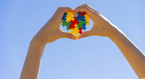 Hands round a heart for autism