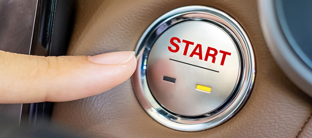 Finger press a car ignition button or START engine inside modern electric automobile. Keyless, change, strategy, vision, innovation and future concept