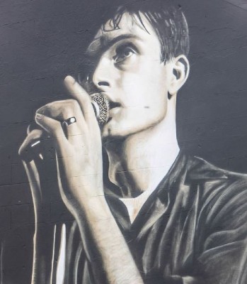 Ian Curtis singing into a microphone