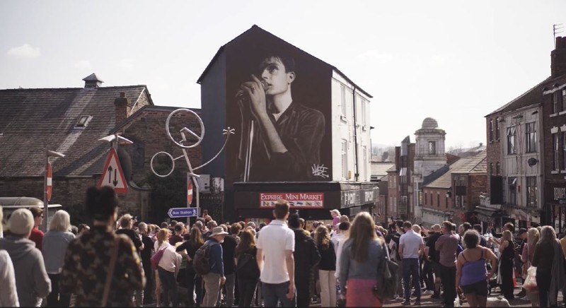 Crowd looking at the Ian Curtis street art mural in Macclesfield