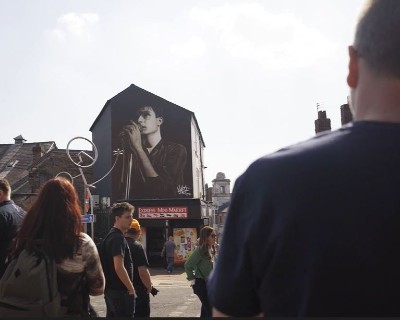 Crowd looking at the Ian Curtis street art mural in Macclesfield