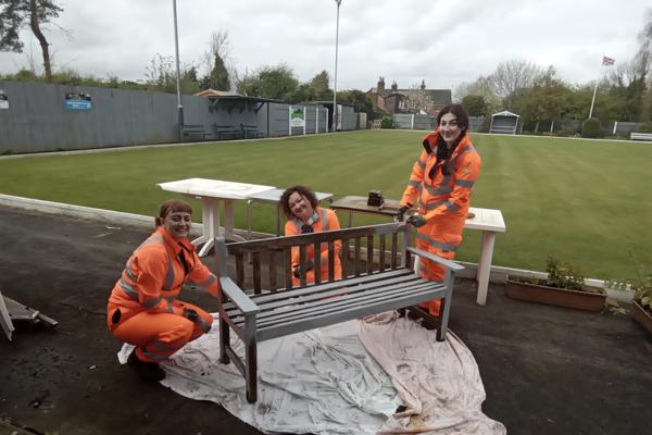 Volunteers from Ringway Jacobs painting one of the benches