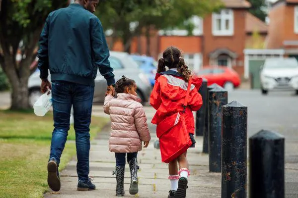 A father walking his two children to school