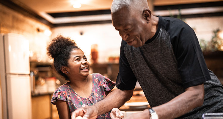 Grand father and grand daughter cooking at home