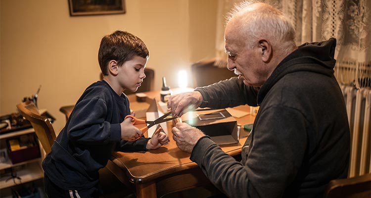 Grandpa and grandson finishing school project at home