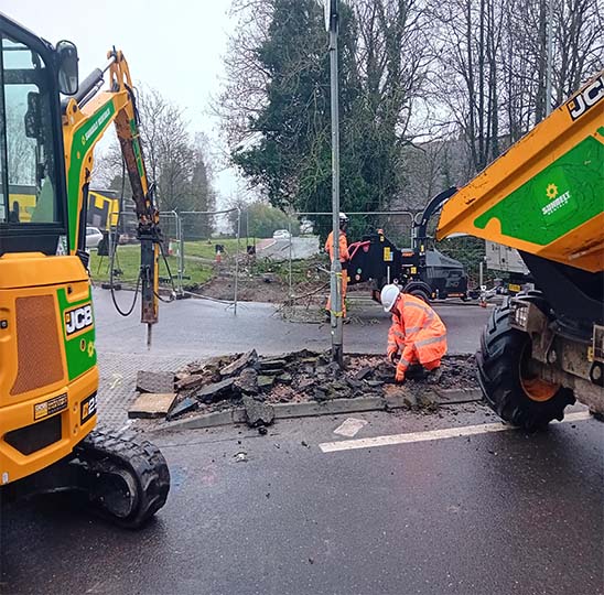 Digger and workman working on the road at the Peacock roundabout