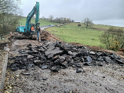 Digger digging up road