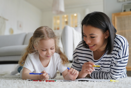 Carer and foster child colouring in together
