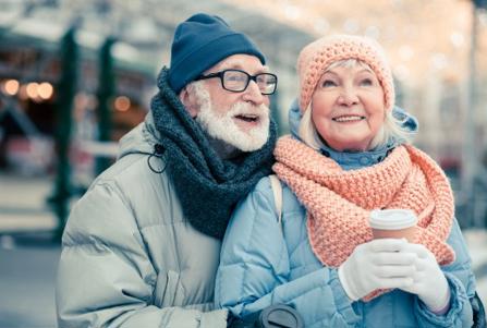 Elderly couple wrapped up warm standing outdoors