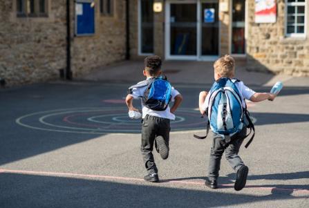 young children running into school