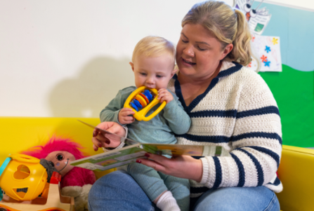Toddler is read to by a childminder