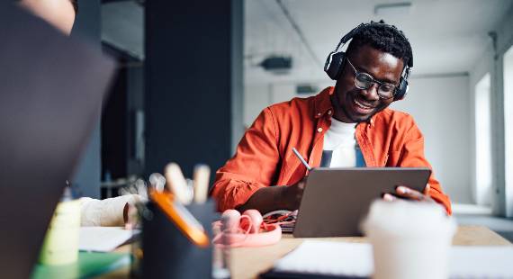 A man wearing headphones using his laptop