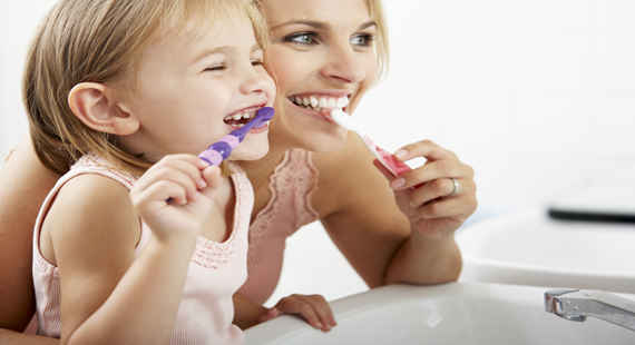 Mother and daughter brushing teeth 570 x 310