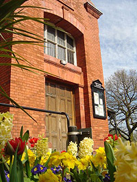 west park red brick building and flowers
