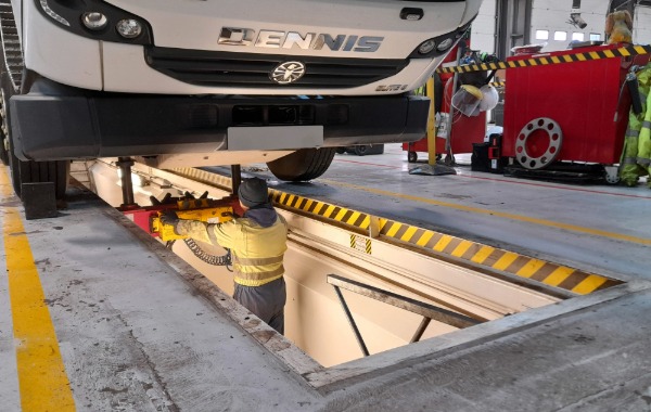 Image of mechanic technician in a bay with waste vehicle